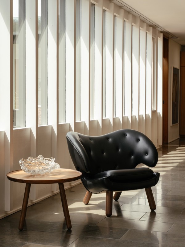 The Pelican Chair with walnut legs and upholstered in 'Elegance' leather in the color 'Black'.