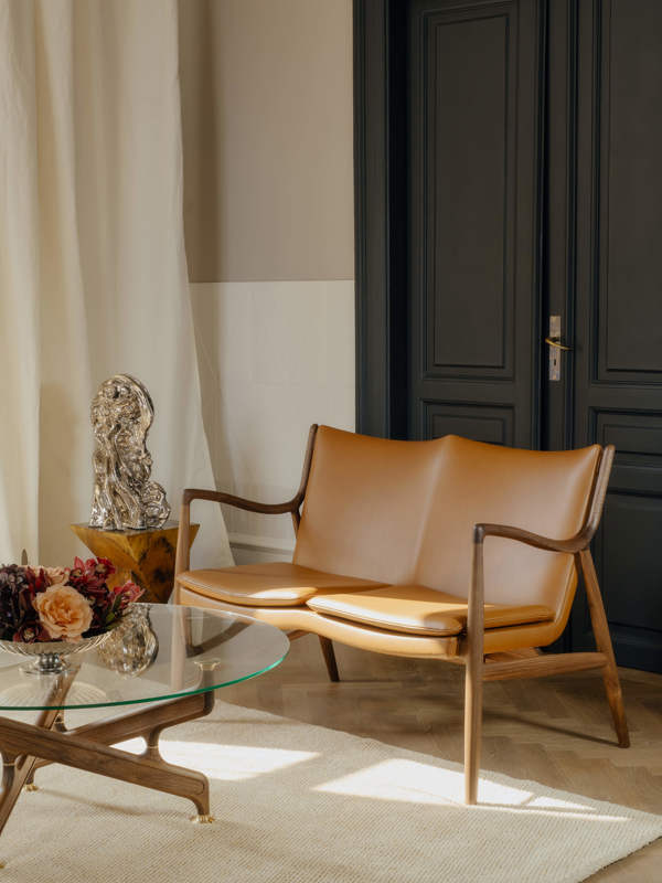 The 45 Sofa in walnut with 'Elegance' leather in the color 'Walnut'.