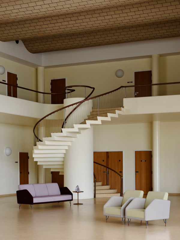 Two 77 Chairs upholstered with 'Fuse' textile in the color '233' on the seat and back cushions and 'Helia’ textile in the colour '421' on the body. Seen alongside the 77 Sofa (three-seater) with ‘Fuse’ textile in the color ‘631’ on the seat and back cushions and ‘Hello’ textile in the color ’693’ on the body.