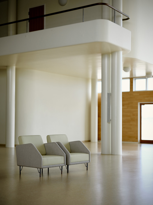 Two 77 Chairs upholstered with 'Fuse' textile in the colour '233' on the seat and back cushions and 'Helia’ textile in the colour '421' on the body. 
