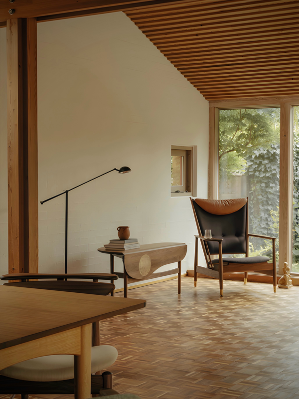 The Whisky Chair in walnut, upholstered in 'Watercolour' with 'Dark Chocolate' on the back and seat, and the cushion in 'Elegance' leather in the color 'Walnut'.