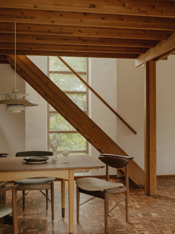 The Bovirke Table in walnut and oak (dark oil) paired with the Reading Chair, the 109 Chair, and the 109 Chair, all in walnut. 
