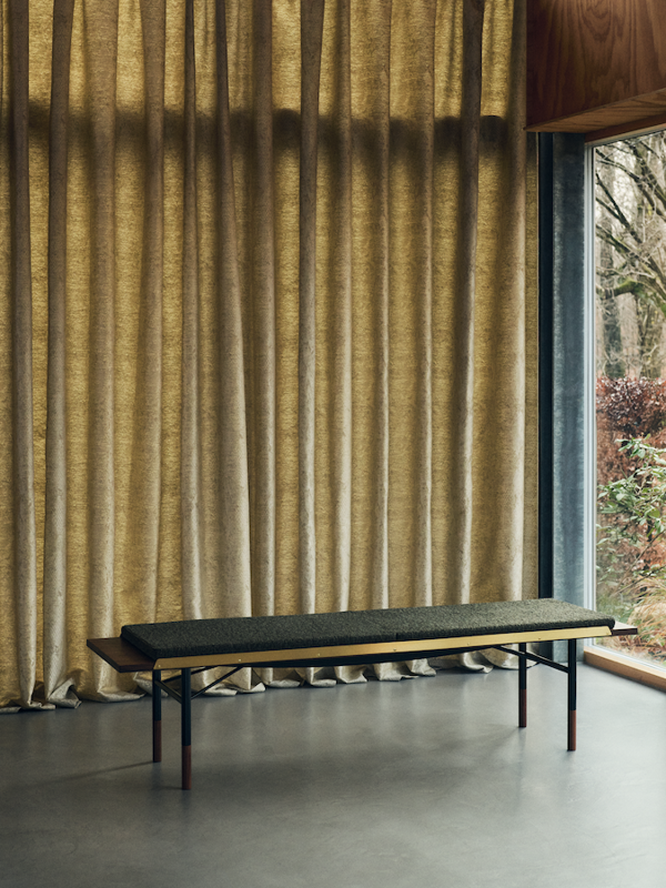 The Table Bench in walnut with black steel legs and brass edges. Cushion with 'Nalia' upholstery in the colour '990'. Photo: Elisabeth Heltoft for Sahco