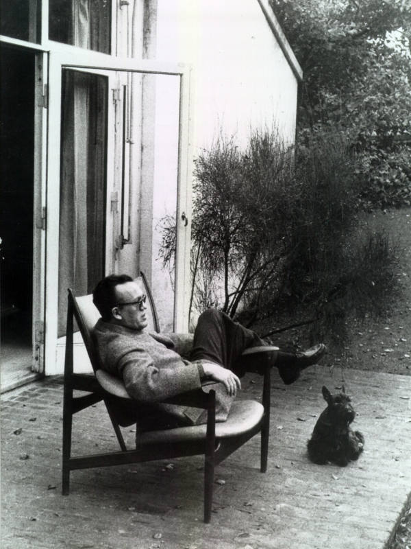 Finn Juhl sitting in the Chieftain Chair in front of his home in Ordrup north of Copenhagen.