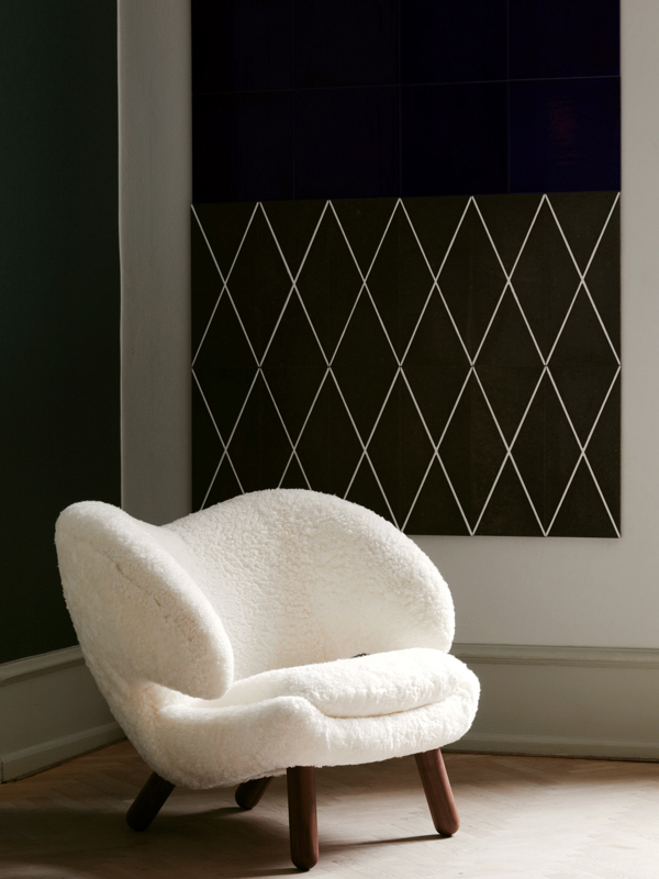 The Pelican Chair with legs in walnut and upholstery in sheepskin in the color 'Off-White'.