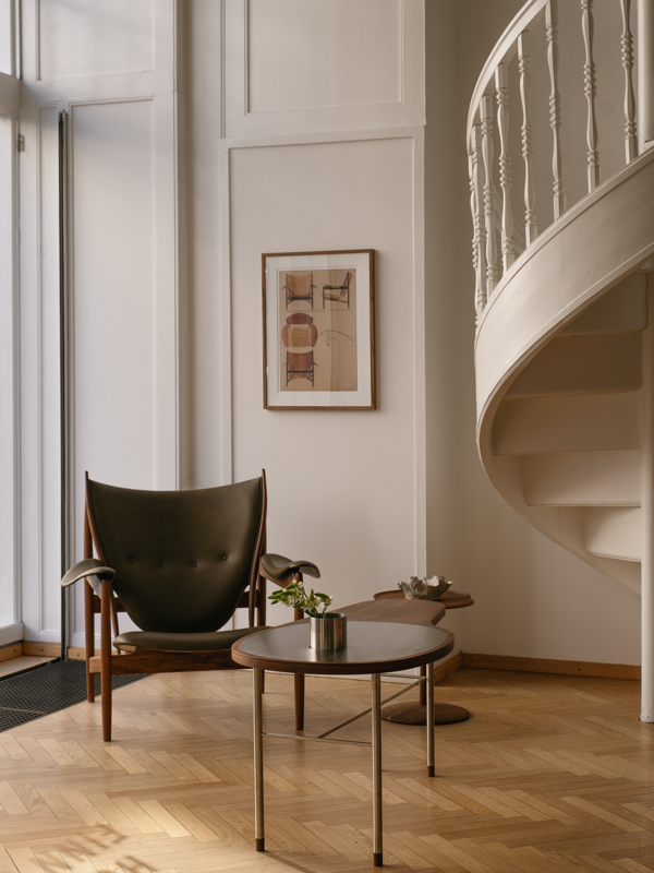 The Ross Coffee Table in walnut, paired with the Chieftain Chair in walnut with 'Terra' leather upholstery in the color 'Jade'. 